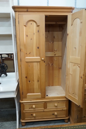 A modern narrow pine wardrobe, the base fitted with three drawers, width 92cm, depth 59cm, height 204cm